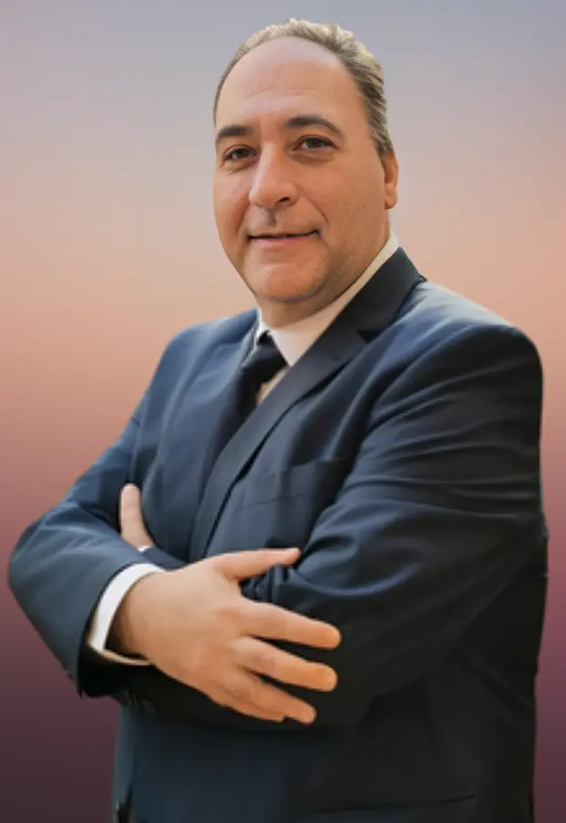 Daniele di Capua Un esperto di viaggi professionale, con un abito elegante, posa con fiducia davanti a uno sfondo sfumato.