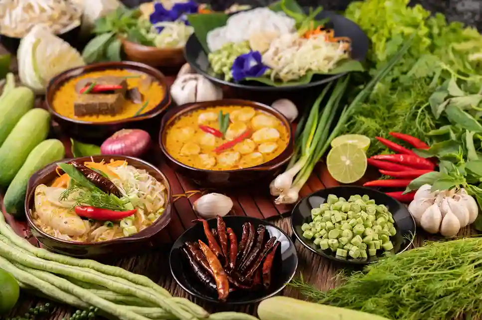 Una varietà di piatti thailandesi circondati da un'abbondanza di ingredienti freschi e spezie. consulente di viaggio