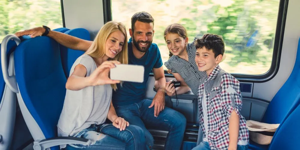 Famiglia felice scatta un selfie durante una vacanza in treno